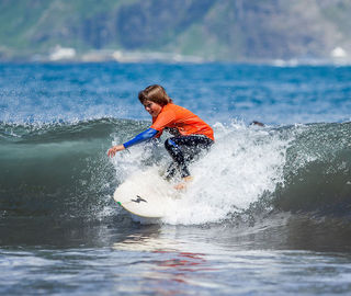 A kid surfing a wave in Madeira